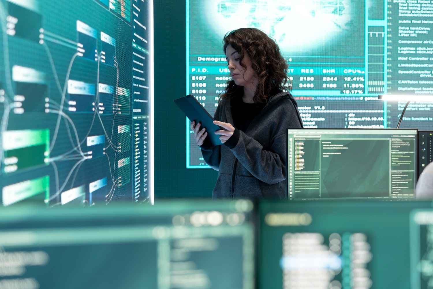 A hacker working on a computer with cybersecurity visuals