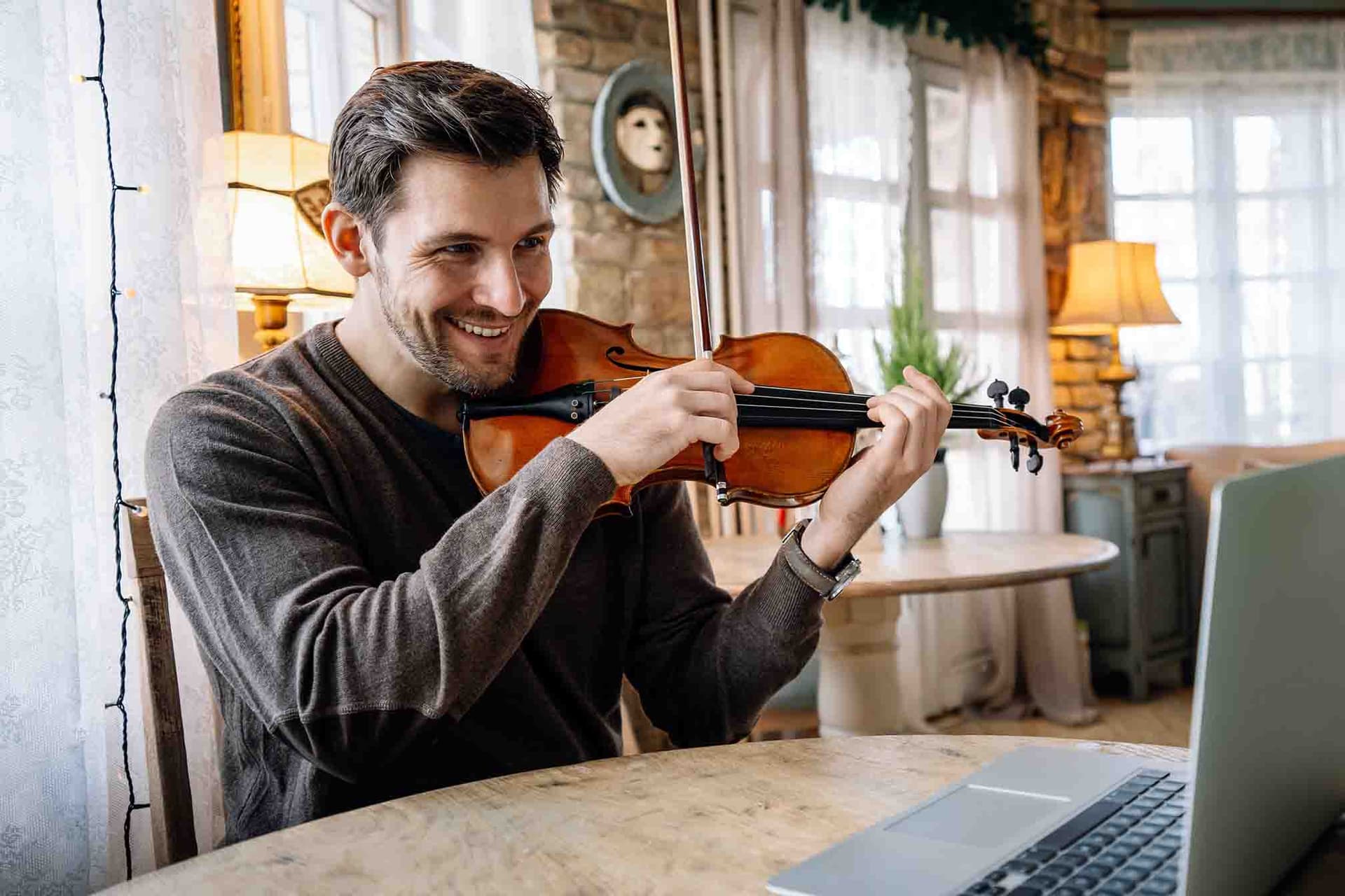A teacher helping a student play the violin