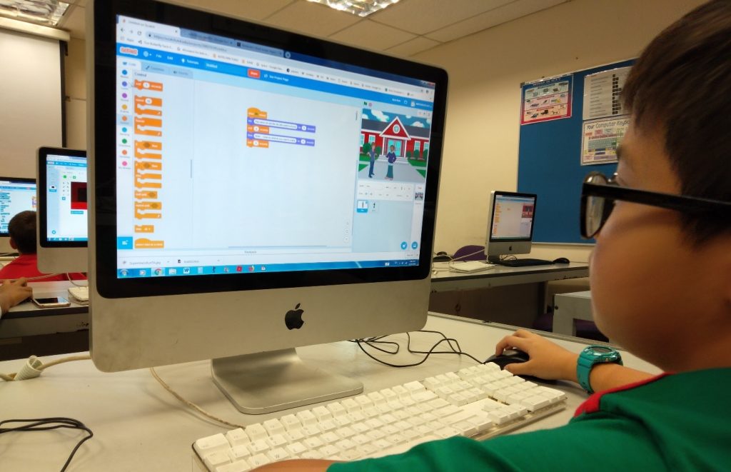 child creating a project on scratch coding